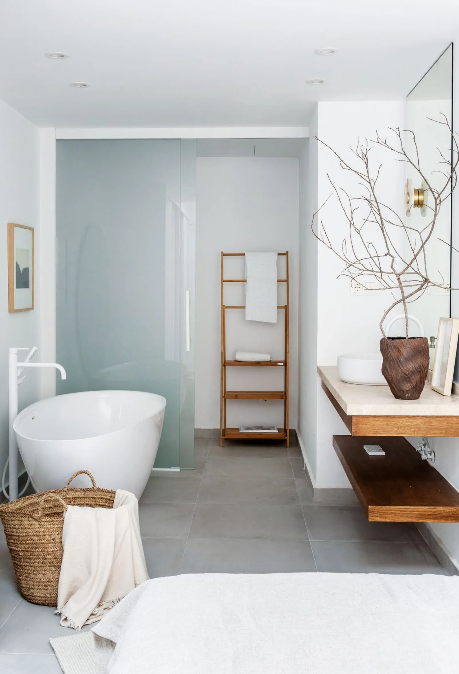 Bathroom with a freestanding bath and a timber vanity shelf
