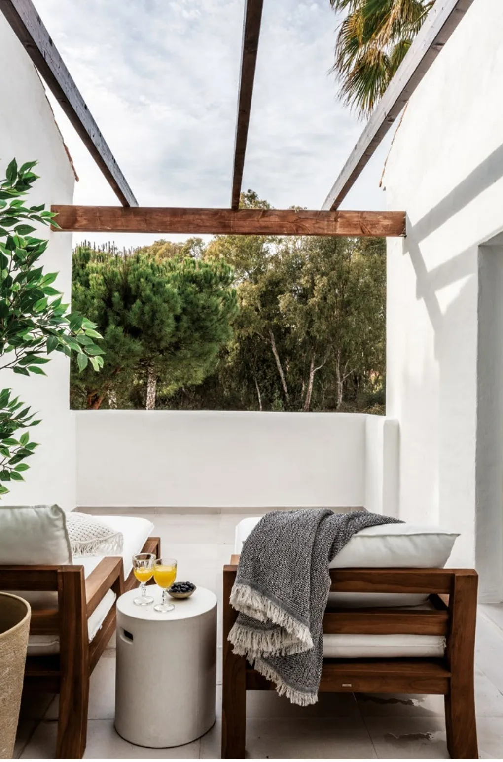 Roof terrace with a timber pergola and two lounge chairs